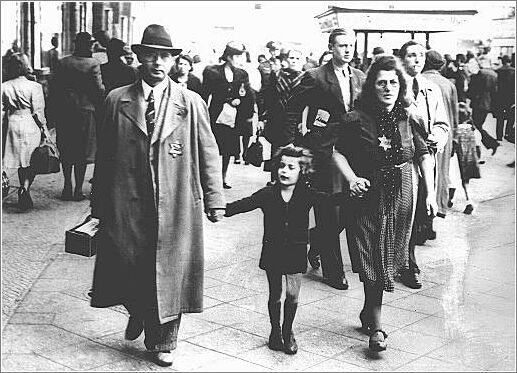 Members of a Jewish family walking along a Berlin street wear the compulsory Star of David. 1941